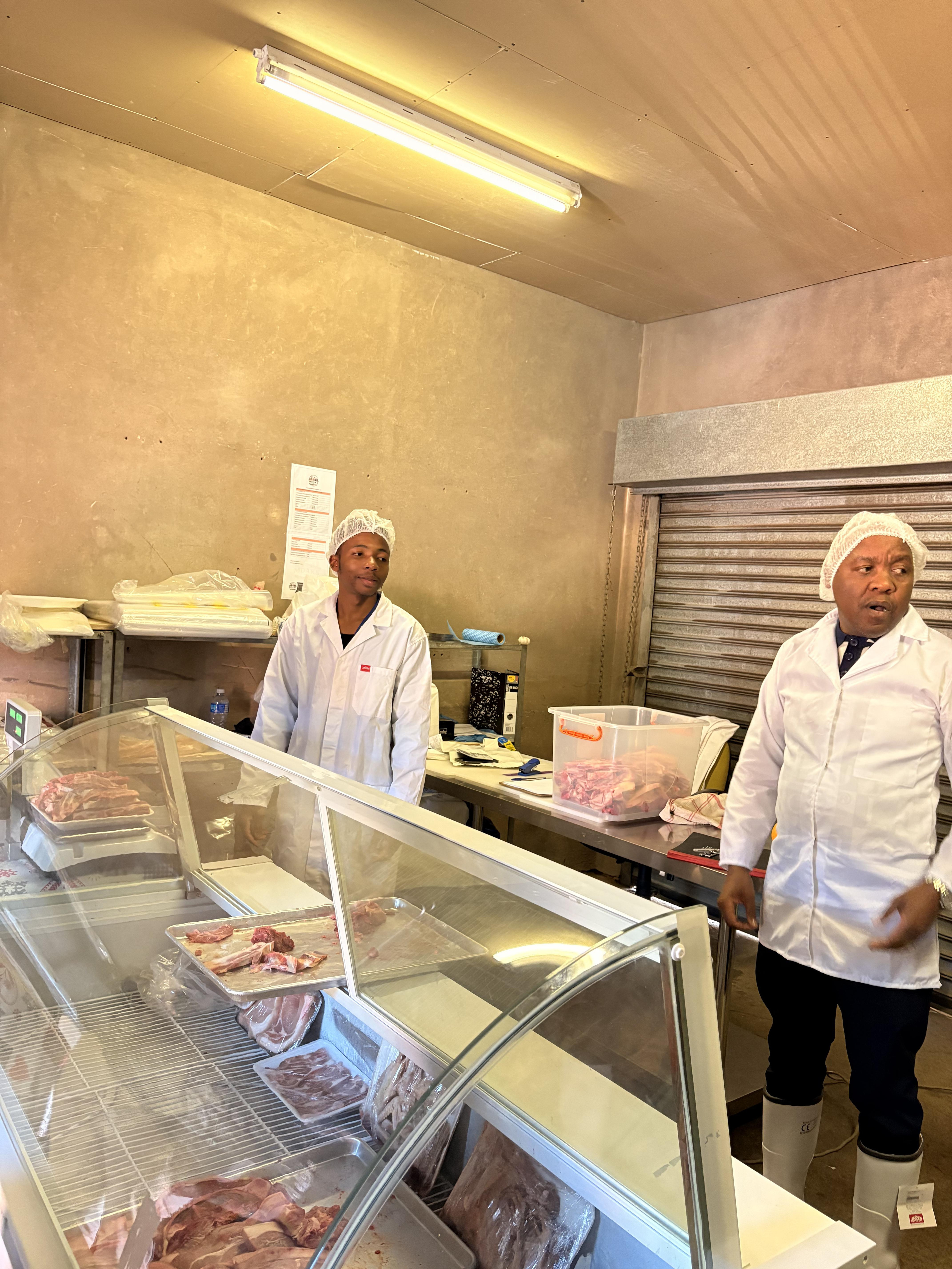 Mdaks Farming butchery staff at the counter with fresh pork on display
