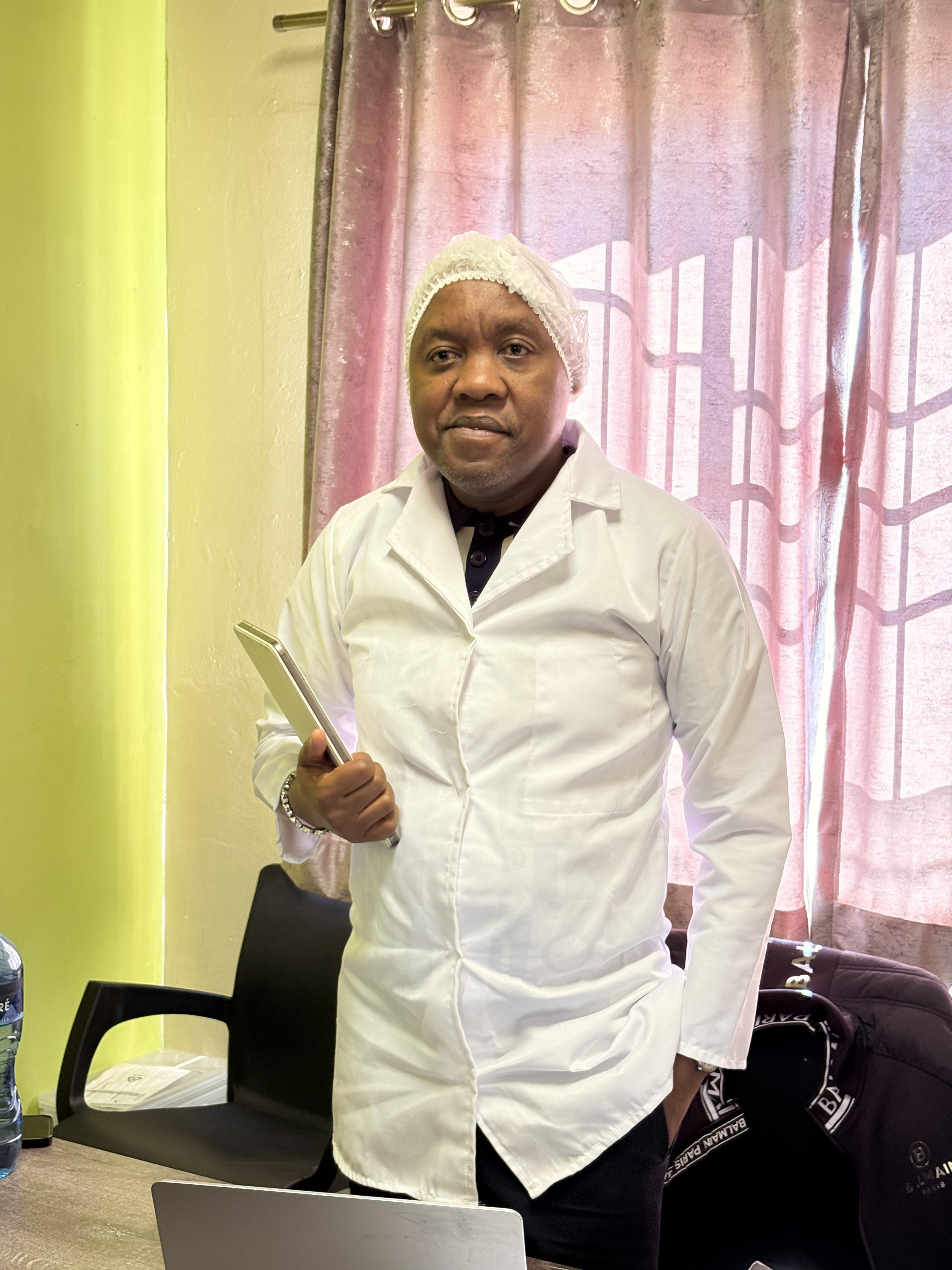 Mdaks Farming owner in white lab coat and hairnet at the piggery office