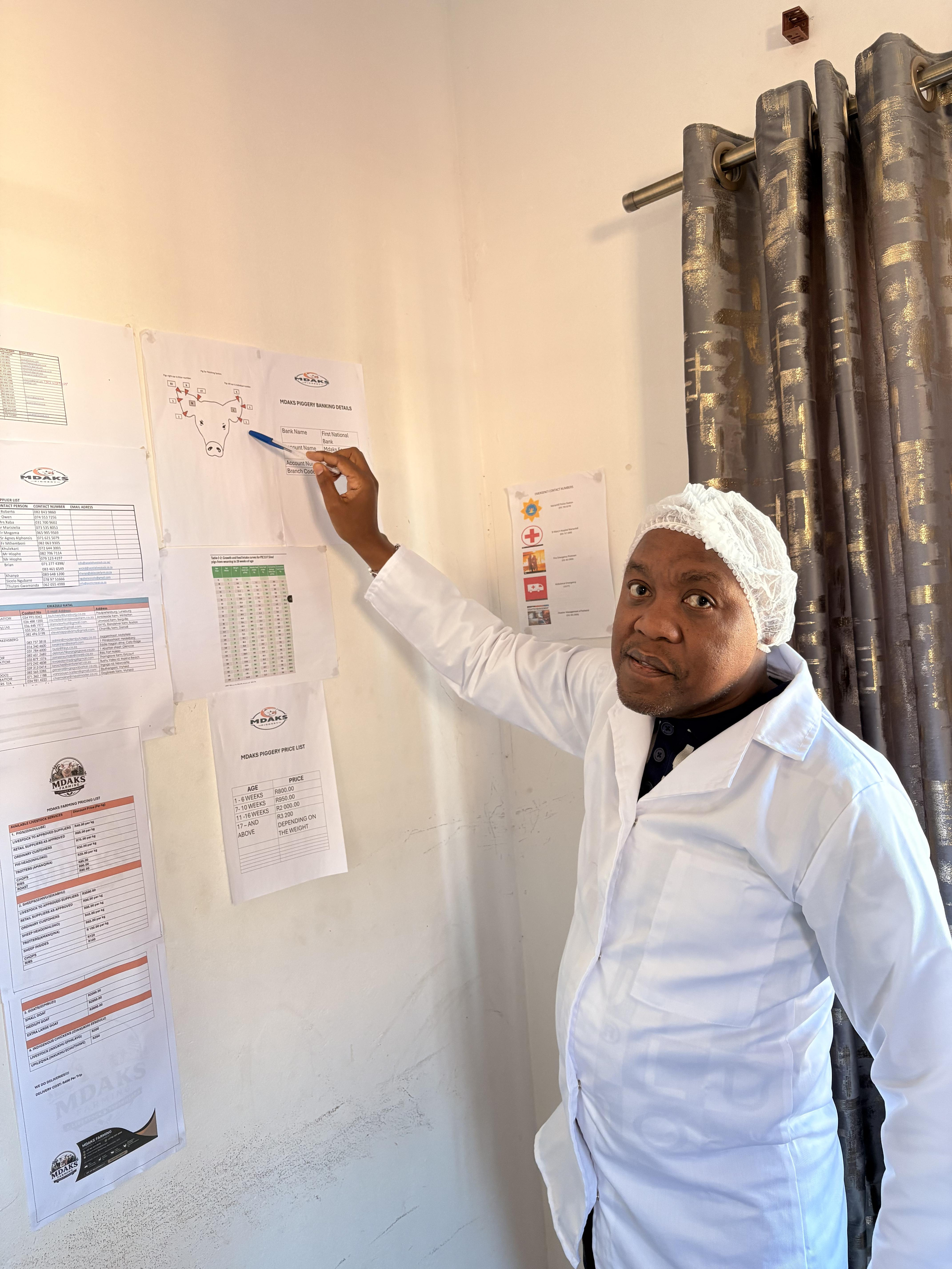 Mdaks Farming staff in hygienic whites serving a customer at the meat counter